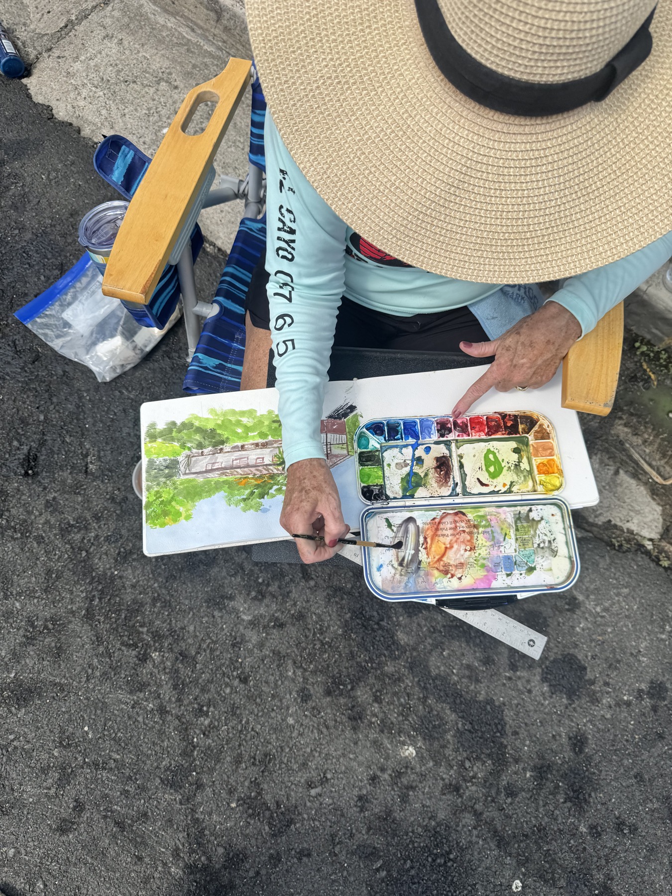 View of a participant’s hands working on a watercolor in Isabel II